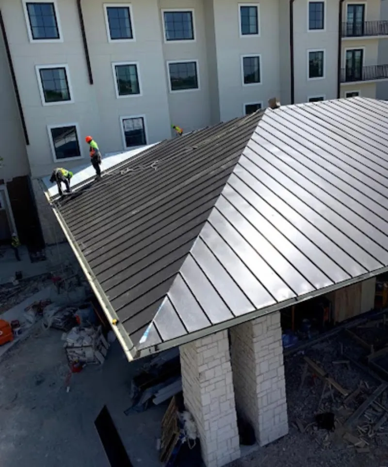 Crew installing standing seam metal roof panels on a commercial project in Sugarmill Woods
